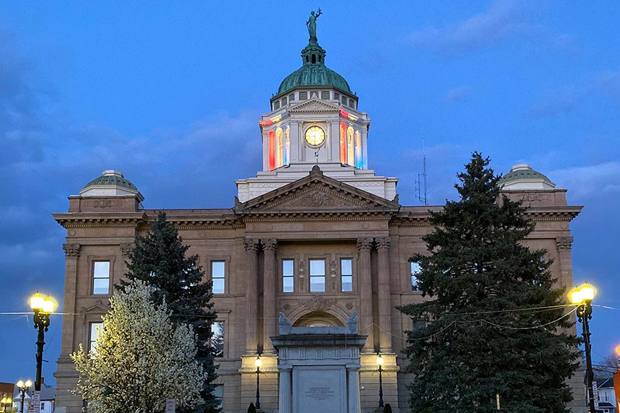 Contact - Upper Sandusky Courthouse With Trees and Lights on During the Evening